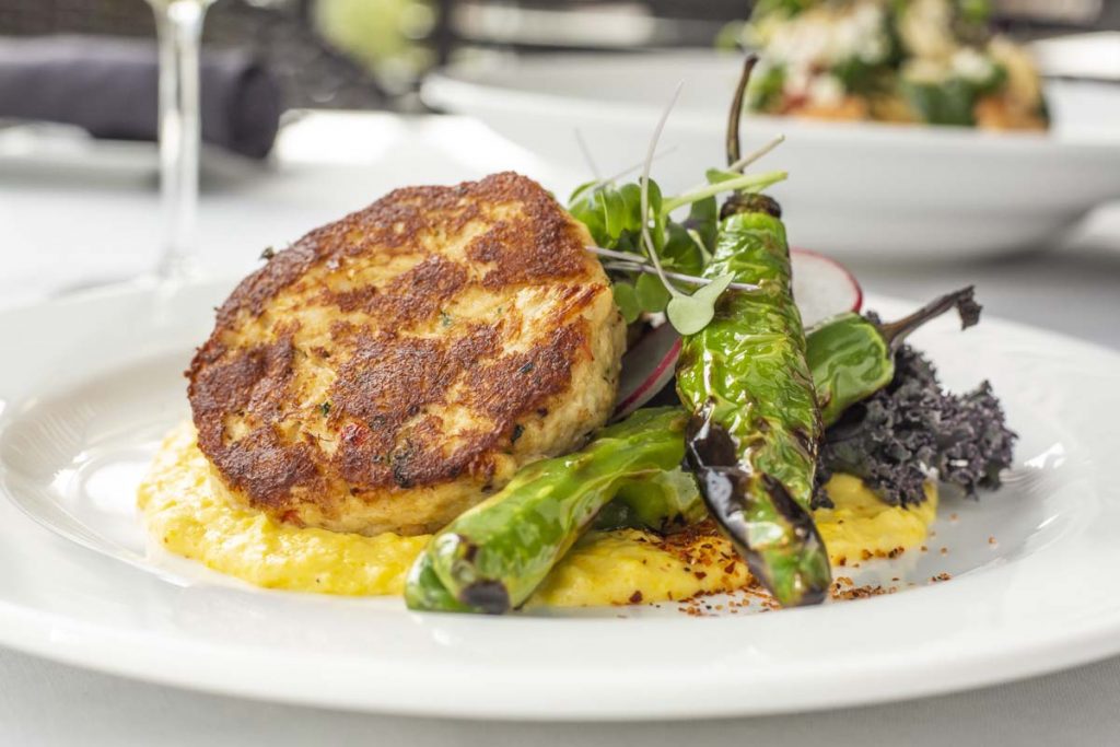 Tucci’s crab cakes plated on polenta with asparagus