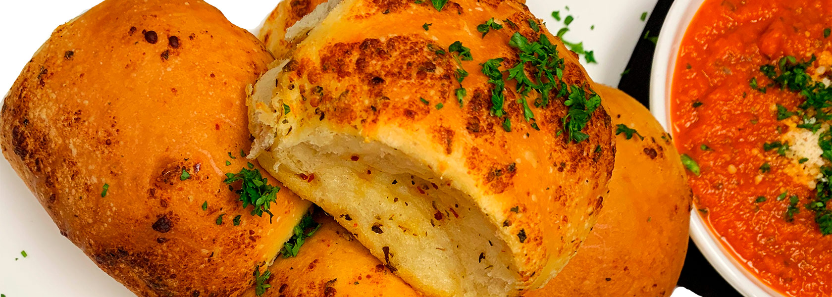 Garlic Herb Rolls plated with marinara dipping sauce.